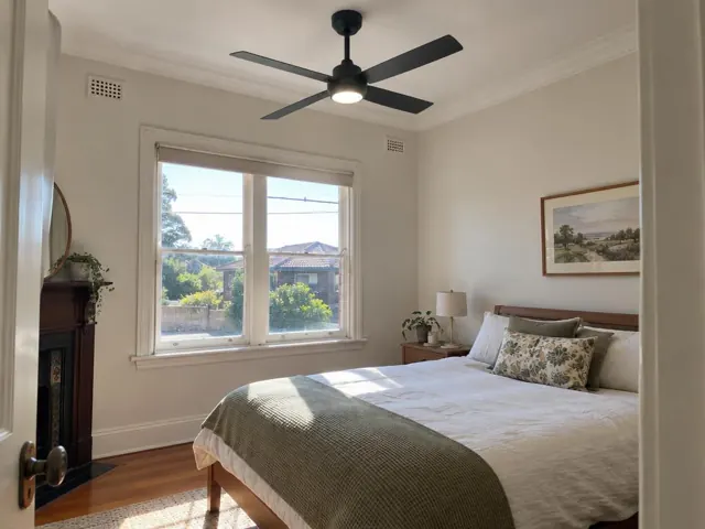 Bedroom with a black ceiling fan above a bed, window and bedside table in Wallsend
